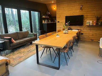Grote eikenhouten vergadertafel voor acht personen, met loungehoek en presentatiescherm